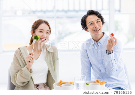 一對年輕夫婦的早餐,包括綠色和黃色蔬菜。 一對年輕夫婦的早餐,包括綠色和黃色蔬菜。 79166136