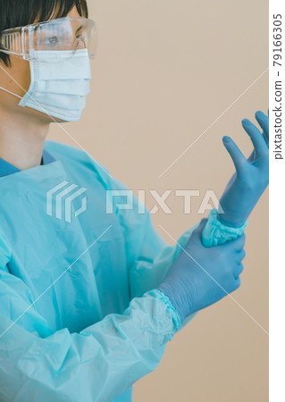 Healthcare workers wearing isolation gowns and nitrile gloves 79166305