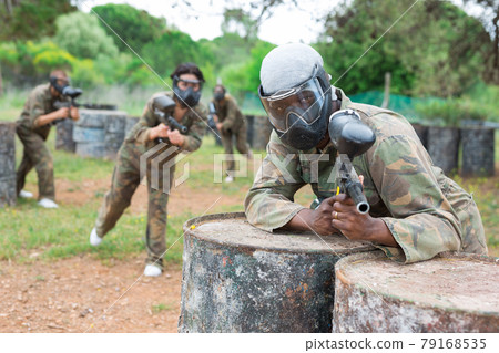 Afro american man paintball player in camouflage with gun Afro american man paintball player in camouflage with gun 79168535