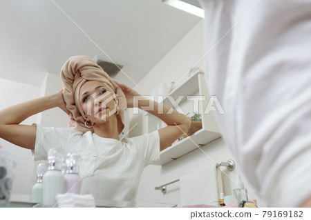 Attractive Woman Looking Into Mirror 79169182