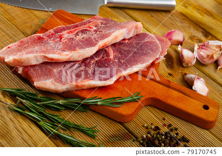 Cooking raw pork shoulder on wooden kitchen table Cooking raw pork shoulder on wooden kitchen table 79170745