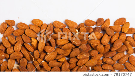 Handful of roasted almond nuts on a white surface Handful of roasted almond nuts on a white surface 79170747