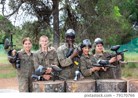 Group portrait of team of paintball players with marker guns Group portrait of team of paintball players with marker guns 79170766