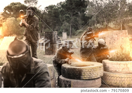 Two active opposing teams with guns playing paintball Two active opposing teams with guns playing paintball 79170809
