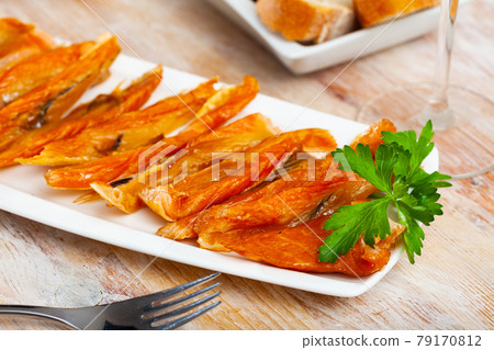 Smoked salmon belly strips on plate on wooden table Smoked salmon belly strips on plate on wooden table 79170812