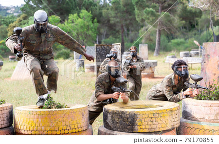 Two active opposing teams with guns playing paintball Two active opposing teams with guns playing paintball 79170855