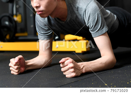 一個年輕人在健身房做自重訓練(平板支撐) 一個年輕人在健身房做自重訓練(平板支撐) 79171020