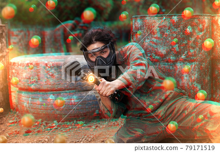 Portrait of asian female with gun on paintball field 79171519