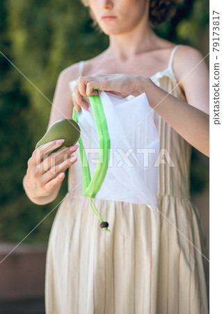 A picture of a young cute woman with a pack of veggies in her hands A picture of a young cute woman with a pack of veggies in her hands 79173817