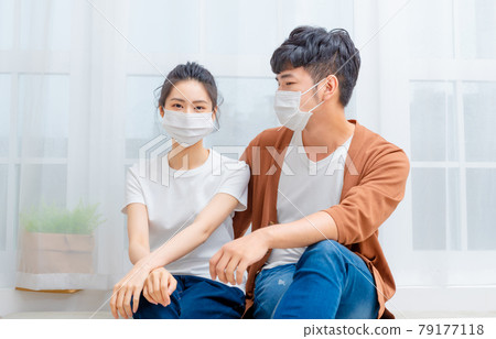 Family wearing masks chatting at home 79177118