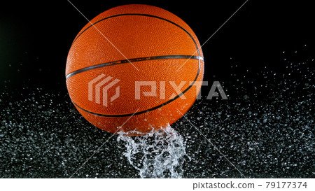 Falling basketball ball on water surface, black background. Falling basketball ball on water surface, black background. 79177374