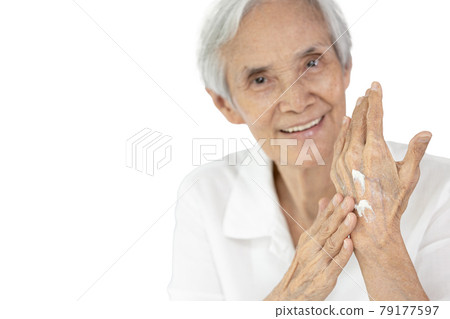 Asian senior woman applying baby lotion on hands,rubbing her palm with hands cream,moisturizer cream used to prevent dryness,nourish dry skin for the old elderly with sensitive skin,skin care concept 79177597