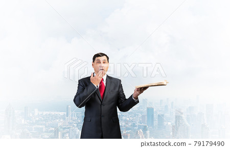 Embarrassed businessman covering mouth with hand Embarrassed businessman covering mouth with hand 79179490