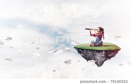 Concept of careless happy childhood with girl looking in spyglas 79180302