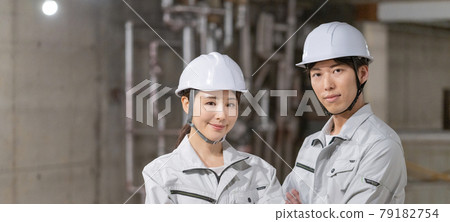 Portrait banner size of two men and women wearing helmets and smiling at the construction site Portrait banner size of two men and women wearing helmets and smiling at the construction site 79182754