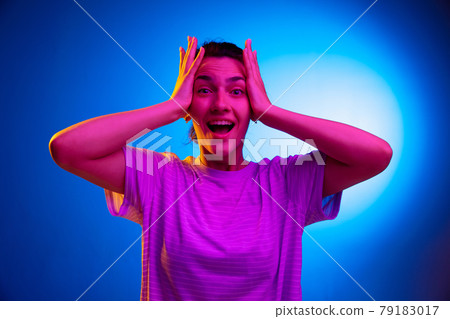 Young woman's portrait on gradient colors studio background in neon. Concept of human emotions. Young woman's portrait on gradient colors studio background in neon. Concept of human emotions. 79183017