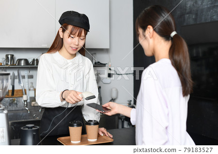 A clerk who makes cashless payment with a barcode reader A clerk who makes cashless payment with a barcode reader 79183527