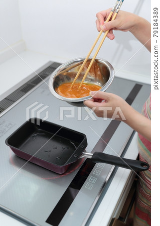 Housewife woman making omelet on IH cooking heater Housewife woman making omelet on IH cooking heater 79184389