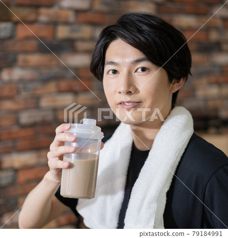 一個汗流浹背的年輕人喝蛋白質方塊的畫像 一個汗流浹背的年輕人喝蛋白質方塊的畫像 79184991