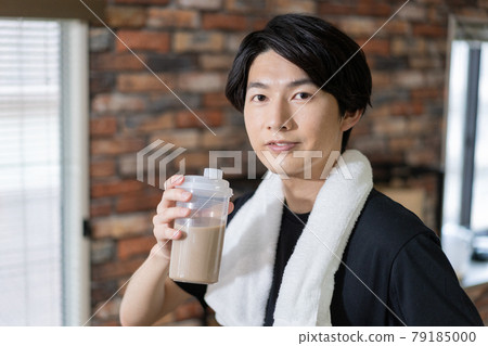 一個汗流浹背的年輕人喝蛋白質的畫像 一個汗流浹背的年輕人喝蛋白質的畫像 79185000