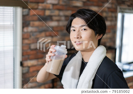 Portrait of a sweaty young man drinking protein 79185002