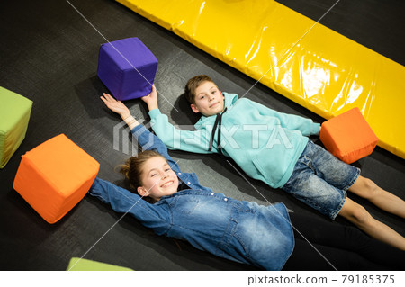 Happy smiling 11 years old kids jumping on trampoline indoors in entertainment center. Active children leisure, jumping and playing on trampoline in sport center. Amusement park. Sport activity Happy smiling 11 years old kids jumping on trampoline indoors in entertainment center. Active children leisure, jumping and playing on trampoline in sport center. Amusement park. Sport activity 79185375
