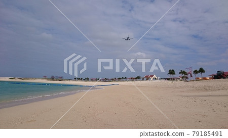 Airplane passing over the beach 79185491