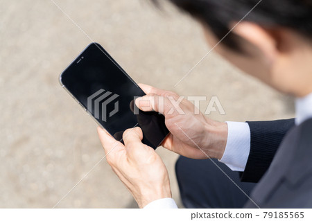 Up the hands of young businessmen who operate smartphones 79185565