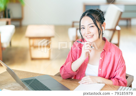 A young woman teleworking in the living room. 79185979