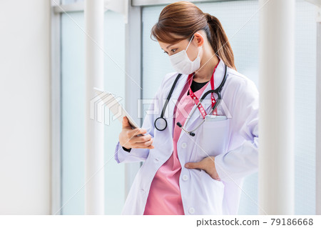 一位年輕的女醫生單手思考平板電腦數據 79186668