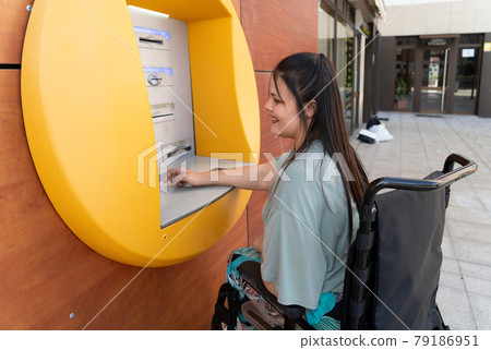 disabled young woman in wheelchair with ATM disabled young woman in wheelchair with ATM 79186951