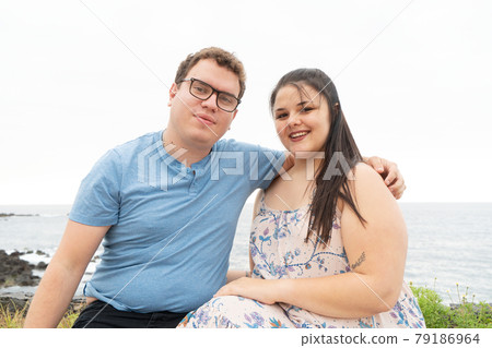 couple in love kissing each other while spending time outdoors on seaside 79186964