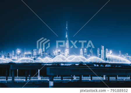 Meydan Bridge and street road or path way on highway with modern architecture buildings in Dubai Downtown skyline at night, urban city at night, United Arab Emirates or UAE. Meydan Bridge and street road or path way on highway with modern architecture buildings in Dubai Downtown skyline at night, urban city at night, United Arab Emirates or UAE. 79188932