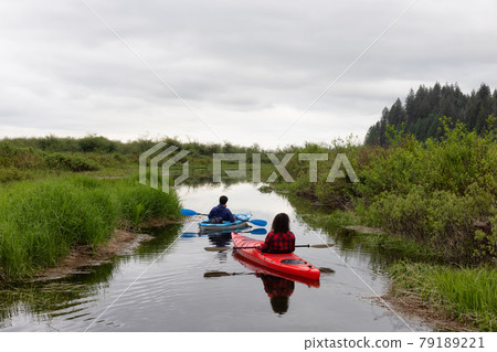 Adventure Friends Kayaking in Kayak surrounded by Canadian Mountain Landscape 79189221