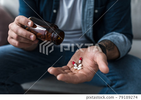 Handful of white pills in male patients palm. Healthcare, treatment, drugs and depression, pain and suicide Handful of white pills in male patients palm. Healthcare, treatment, drugs and depression, pain and suicide 79189274