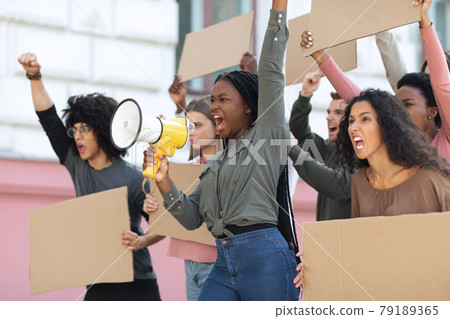 Motivated african american woman with loudspeaker over crowd Motivated african american woman with loudspeaker over crowd 79189365
