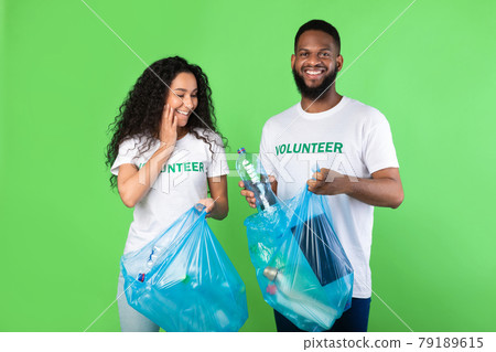 Multicultural Volunteers Picking Plastic Litter In Bags Over Green Background Multicultural Volunteers Picking Plastic Litter In Bags Over Green Background 79189615