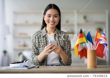 Cheerful asian young lady using smartphone, having English class 79189618