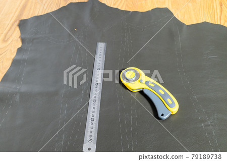 steel ruler and rotary cutter on wooden table 79189738