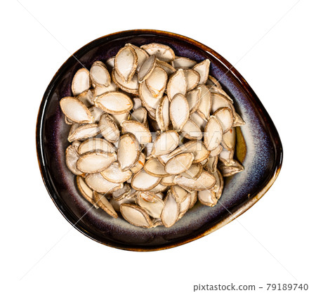 whole pumpkin seeds in ceramic bowl isolated whole pumpkin seeds in ceramic bowl isolated 79189740