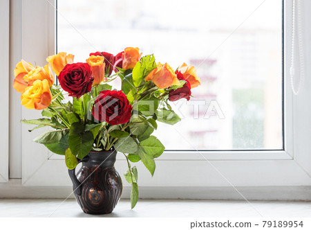 red and yellow roses in ceramic jug on window sill red and yellow roses in ceramic jug on window sill 79189954