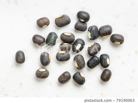 several whole black urad beans close up on gray several whole black urad beans close up on gray 79190063