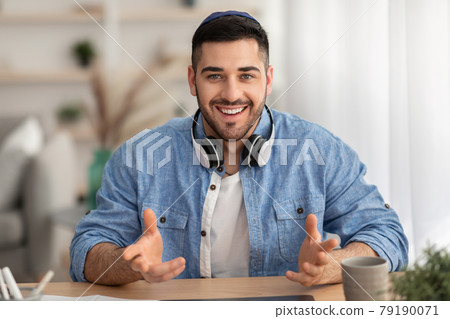 Cheerful man having video call using laptop and talking Cheerful man having video call using laptop and talking 79190071