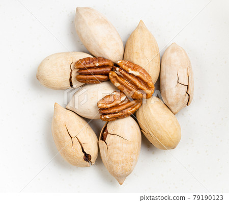 pile of cracked and shelled pecan nuts close up 79190123
