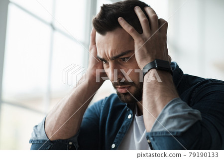 Sad and worried man sit at home couch feeling negative emotions, depression and problems 79190133