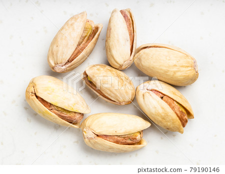 several raw ripe pistachio nuts close up on gray several raw ripe pistachio nuts close up on gray 79190146
