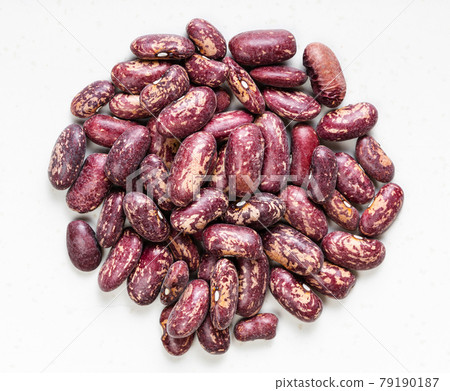 pile of red spotted pinto beans close up on gray 79190187