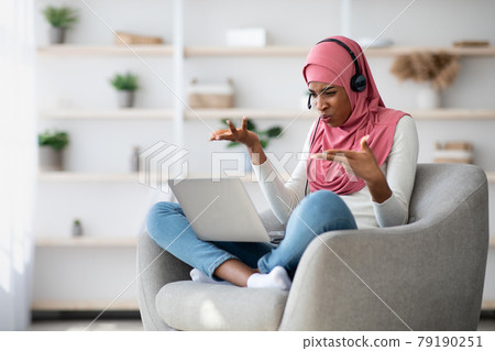 Stressed Black Muslim Woman In Hijab Suffering Problems With Laptop At Home Stressed Black Muslim Woman In Hijab Suffering Problems With Laptop At Home 79190251