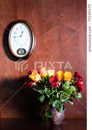 wall clock and fresh red and yellow roses in jug wall clock and fresh red and yellow roses in jug 79190379