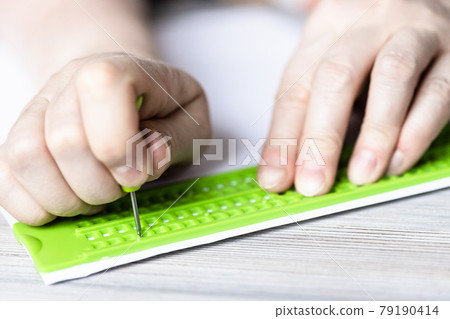 front view of writing in braille with slate 79190414